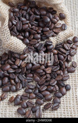 Des grains de café dispersés dans le sac sur un fond en toile de fond de gros plan Banque D'Images