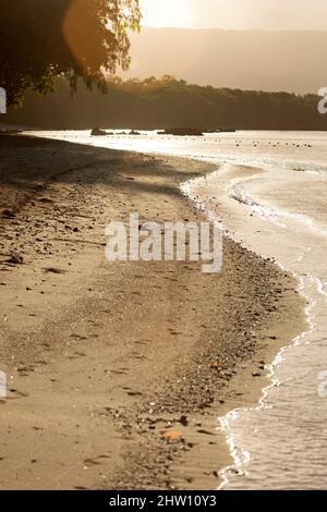 Matin sur une plage baignée par l'eau de l'océan Indien à Flic an Flac à Maurice. La baie de Tamarin se lave contre la rive sablonneuse. Banque D'Images