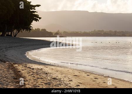 Plage lappée par l'eau de l'océan Indien à Flic an Flac à Maurice. La baie de Tamarin se lave contre la rive sablonneuse. Banque D'Images