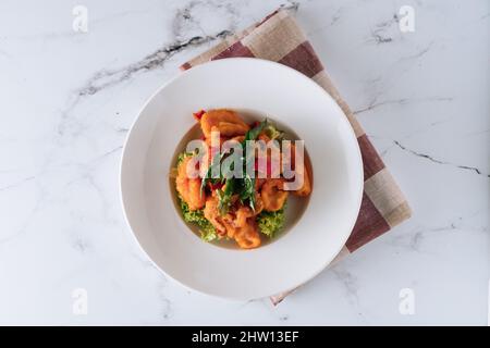 Calmars aux œufs salés frits dans un plat isolé sur le dessus du tapis, sur fond de marbre gris Banque D'Images