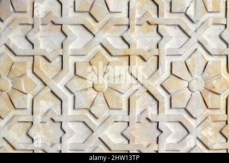 Arrière-plan de fleurs de style arabe, gros plan. Texture avec motif africain sur le mur de pierre. La texture sur la surface en béton est orange. Banque D'Images