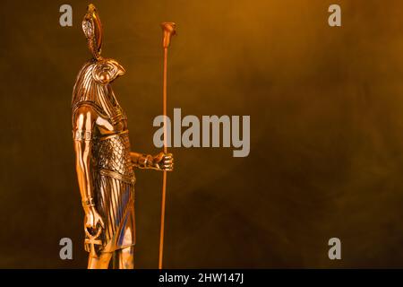 Statue en métal doré du Dieu du soleil égyptien Ra sur un fond noir avec de la fumée. Photo de haute qualité Banque D'Images