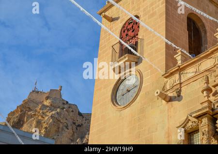 Tour d'horloge artistique de la basilique Sainte-Marie d'Alicante. En arrière-plan le Castillo de Santa Bárbara sur une montagne sous ciel bleu clair. Valen Banque D'Images