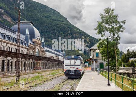 Espagne, Aragon, Huesca, Canfranc, gare internationale (altitude 1200 mètres), un train espagnol local de Jaca est garée en face de la façade du bâtiment principal, transformé en un musée de l'ancienne ligne de chemin de fer Pau-Zaragoza, abandonné depuis 1970, la réhabilitation de la gare en un hôtel de luxe Banque D'Images