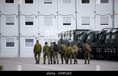 Rukla, Lituanie. 03rd mars 2022. Des soldats du bataillon multinational du groupe de combat de la présence avancée renforcée de l'OTAN, dirigé par les Forces armées allemandes, marchent à côté de camions militaires sur la base militaire. Credit: Bernd von Jutrczenka/dpa/Alamy Live News Banque D'Images