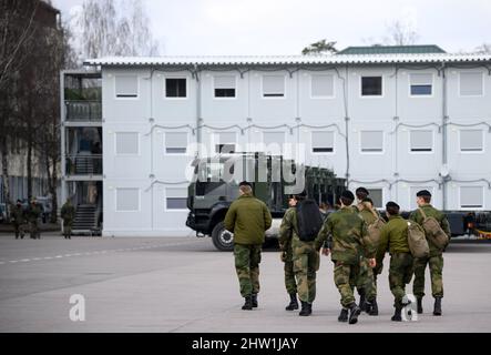 Rukla, Lituanie. 03rd mars 2022. Des soldats du bataillon multinational du groupe de combat de la présence avancée renforcée de l'OTAN, dirigé par les Forces armées allemandes, marchent à côté de camions militaires sur la base militaire. Credit: Bernd von Jutrczenka/dpa/Alamy Live News Banque D'Images
