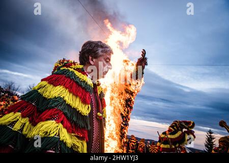 Antonio Carneiro, Président du Conseil paroissial de Podence, rejoint les Caretos lors de l'incendie d'Entrudo (un géant de Careto) lors de la célébration du Carnaval de Podence. Dans le village portugais de Podence, dans la municipalité de Macedo de Cavaleiros, pendant le carnaval, les hommes portent le costume traditionnel, connu sous le nom de « Caretos », portent des masques en laiton ou en bois et portent des costumes en laine colorés. Ils crient et chassent les gens dans les rues pour les effrayer, en particulier les femmes célibataires. Caretos de Podence a été déclaré patrimoine culturel immatériel de l'humanité par l'UNESCO le 2019 décembre. L'événement se termine par Banque D'Images