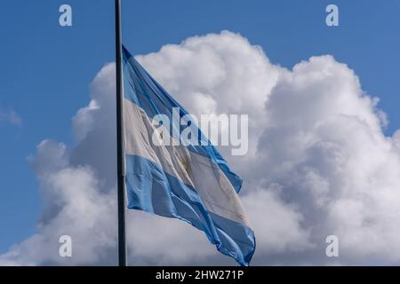 Photo à angle bas du drapeau de l'Argentine sur un mât contre un fond ciel nuageux Banque D'Images