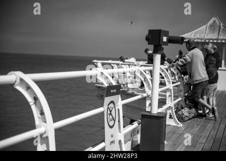 Photo en niveaux de gris de personnes sur Cromer Pier, Royaume-Uni Banque D'Images