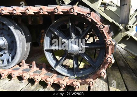 gros plan de l'ancienne roue du réservoir militaire sur les chenilles caterpillar. Une roue de véhicule militaire d'époque à l'extérieur d'un musée sur un plancher en bois Banque D'Images