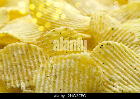 Fond défoqué avec de délicieux chips de pommes de terre ondulées aux herbes. Mise au point sélective Banque D'Images