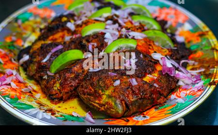 Poisson grillé, dorade avec ajout d'épices, d'herbes et de citron sur la plaque du gril. Banque D'Images