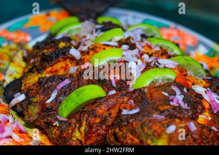 Poisson grillé, dorade avec ajout d'épices, d'herbes et de citron sur la plaque du gril. Banque D'Images