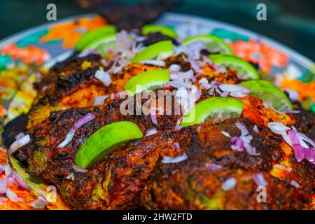 Poisson grillé, dorade avec ajout d'épices, d'herbes et de citron sur la plaque du gril. Banque D'Images