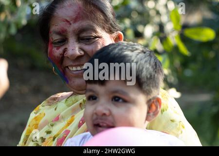 Joyeux enfant indien asiatique et grand-mère appréciant le Festival des couleurs avec la poudre de couleur Holi appelée Gulal ou rang Banque D'Images