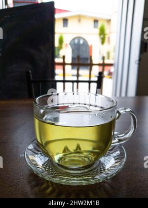 Tasse transparente de thé chaud sur une table en bois sur un fond de nature Banque D'Images