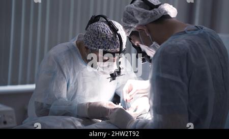 Les chirurgiens effectuent une opération sous anesthésie. Action. Deux chirurgiens professionnels travaillent dur pour éliminer ou traiter la maladie. Chirurgie et opération. Banque D'Images