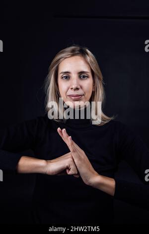 Une jeune femme forte prête à lutter contre les abus physiques et psychologiques domestiques, le gazééclairage, l'agression relative et les injustices sociales sur le noir Banque D'Images