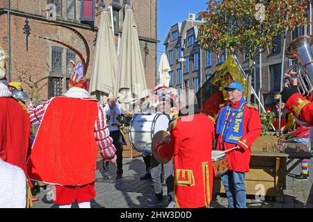 Nimègue, pays-Bas - février 27. 2022: Vue sur le groupe jouant des musiciens en costumes rouges de carnaval sur la place du marché le jour ensoleillé Banque D'Images