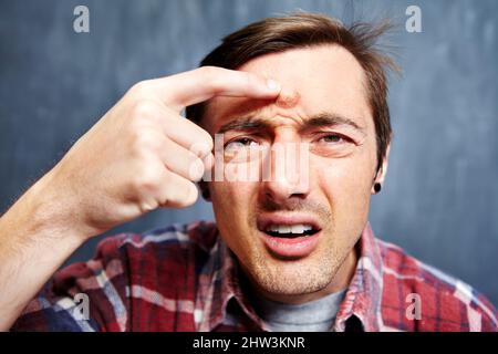 Je ne peux pas sortir comme ça. Portrait d'un jeune homme avec un bouton géant sur son front. Banque D'Images