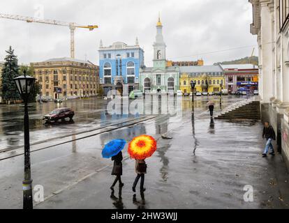 Des piétons avec des parasols colorés marchent sur la place historique du contrat (Kontraktova ploshcha), Podil, Kiev (Kiev), capitale de l'Ukraine, le jour des pluies Banque D'Images