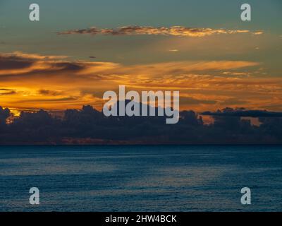 Lever du soleil sur l'océan, ciel peint.Soleil d'or brillant à travers les nuages reflétés dans l'eau de mer, Coastal NSW Australie Banque D'Images