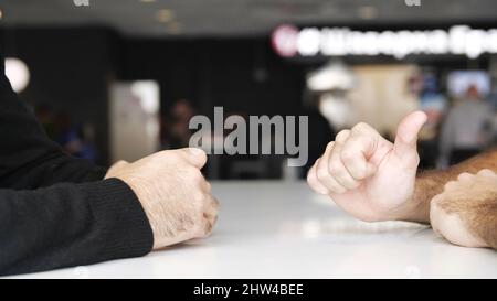 Gros plan sur les mains des hommes lors de négociations efficaces. Les mains de deux hommes se déplaçant pendant la conversation, le concept d'affaires et la conclusion d'un accord. Banque D'Images