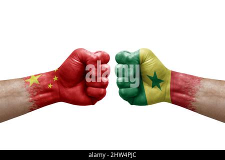 Deux mains poinçonner l'une à l'autre sur fond blanc. Les drapeaux de pays ont peint des poings, le concept de crise de conflit entre la chine et le sénégal Banque D'Images