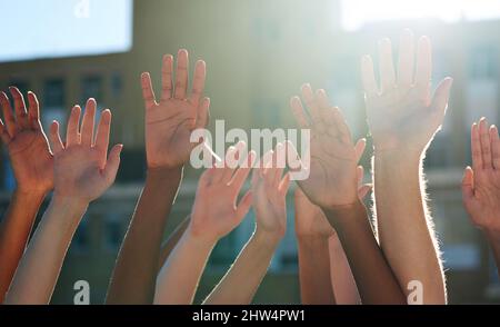 Nous en sommes un. Photo rognée d'un groupe diversifié de personnes qui se soulèvent les mains. Banque D'Images