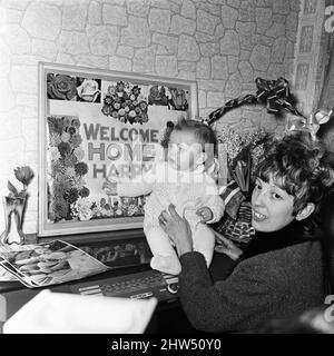 Mme Rita Eddom, dont le mari Harry, était le seul survivant du chalutier Ross Cleveland, rentre à la maison après un voyage aller-retour de 2000 km à son chevet de l'hôpital. Elle a constaté qu'un grand accueil avait déjà été préparé pour son mari, qui espère être de retour d'Islande dans quelques jours. La première chose qu'elle a fait était de se précipiter à l'étage pour voir sa petite fille, Natalee. 11th février 1968. Banque D'Images