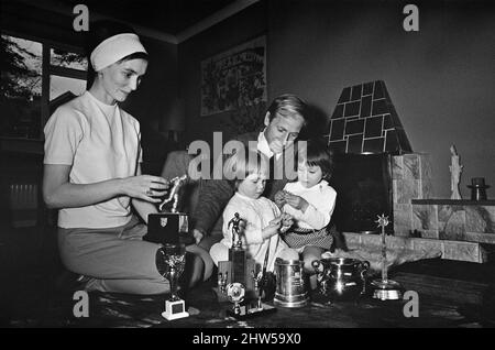 Bobby Charlton, de Manchester United, présente ses nombreux trophées qu'il a remportés à ses deux enfants Andrea et Suzanne ay, leur domicile à Lymm, Cheshire. La femme Norma est également représentée sur la photo. 29th mars 1967. Banque D'Images