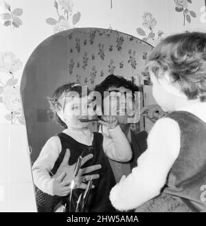 Freddie Garrity, chanteuse en chef du groupe pop de Manchester Freddie et The Dreamers, photographiée chez lui avec sa fille de trois ans Jackie, se brossant les dents.24th mai 1967. Banque D'Images