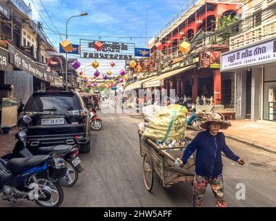 Une dame cambodgienne tire un chariot transportant des marchandises dans la rue. Banque D'Images