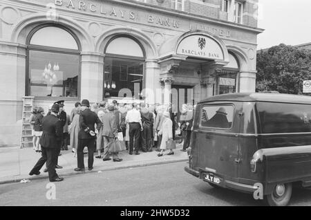 Le premier guichet automatique de Worlds, Cash machine, est dévoilé à la Barclays Bank, à Enfield, Middlesex, juste au nord de Londres. 27th juin 1967. La photo montre la foule de clients et de spectateurs locaux, voyant le premier guichet automatique au monde travailler pour la première fois. Barclays ATM, 27th juin 1967. Sir Thomas Bland, vice-président de Barclays Bank, dévoile un robot de caisse qui distribue de l'argent à tout moment du jour ou de la nuit. Conçue et développée conjointement avec de la rue instruments et le service des services de gestion des banques, la machine BarclayCash est installée dans la succursale d'Enfield. L'acteur Reg Varney a pris le temps de quitter Filmi Banque D'Images