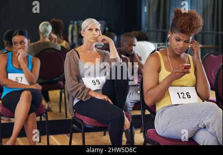 Papillons dans l'estomac Prise de vue d'un groupe de jeunes danseurs à la recherche d'anxiété en attendant leurs auditions de danse. Banque D'Images