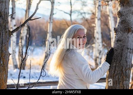 Femme âgée posant dans la forêt d'hiver Banque D'Images