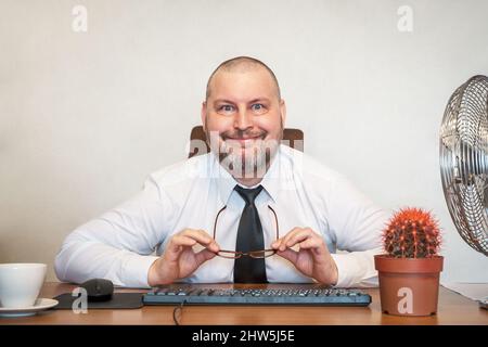 L'homme décrit comiquement le travail d'un homme d'affaires. Il montre le contentement et la joie sur son visage et sa posture. Banque D'Images