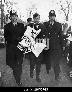 Le manifestant nationaliste gallois est conduit par des policiers à l'extérieur du Temple de la paix, à Cardiff, lors de la conférence All Wales pour planifier les célébrations de l'investiture du Prince de Galles, vendredi 17th novembre 1967. Banque D'Images