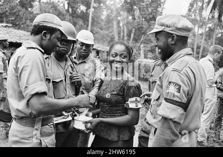 Les soldats de Biafran vus ici en appréciant de la nourriture détenue par un travailleur de l'aide pendant le conflit de Biafran, 11th juin 1968. La guerre civile nigériane, également connue sous le nom de guerre du Biafran, a duré deux ans et demi, du 6 juillet 1967 au 15 janvier 1970, et a été combattue pour contrer la sécession du Biafra du Nigeria. Le peuple indigène Igbo de Biafra a estimé qu'il ne pouvait plus coexister avec le gouvernement fédéral dominé par le Nord après l'indépendance de la Grande-Bretagne. Les tensions politiques, économiques, ethniques, culturelles et religieuses se sont finalement retendues dans la guerre civile après le coup d'État militaire de 1966, le Banque D'Images