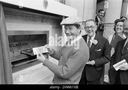 Le premier guichet automatique de Worlds, Cash machine, est dévoilé à la Barclays Bank, à Enfield, Middlesex, juste au nord de Londres. 27th juin 1967. La photo montre l'acteur Reg Varney dans sa casquette blanche. Barclays ATM, 27th juin 1967. Sir Thomas Bland, vice-président de Barclays Bank, dévoile un robot de caisse qui distribue de l'argent à tout moment du jour ou de la nuit. Conçue et développée conjointement avec de la rue instruments et le service des services de gestion des banques, la machine BarclayCash est installée dans la succursale d'Enfield. L'acteur Reg Varney a pris le temps de filmer la série télévisée « Beggar Your Neighbor » à Northwood à Banque D'Images