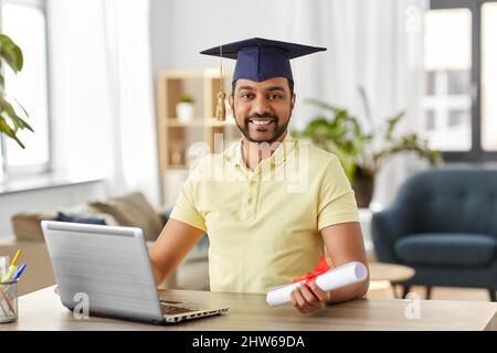 étudiant indien avec ordinateur portable et diplôme à la maison Banque D'Images