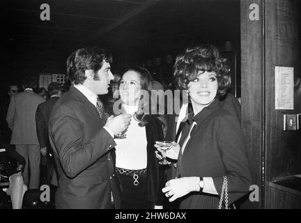 Réception de mariage du réalisateur polonais Roman Polanski et de sa mariée, l'actrice américaine Sharon Tate, ont eu lieu au London Playboy Club après leur mariage au bureau d'inscription de Chelsea. L'actrice Joan Collins et son mari Anthony Newley discutant avec un autre invité à la réception. 20th janvier 1968. Banque D'Images