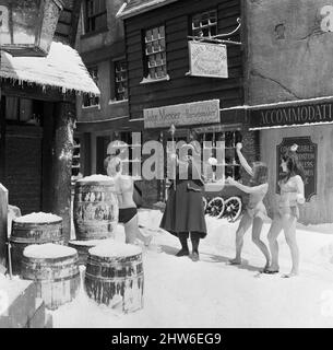 Tournage d'Oliver ! Aux studios Shepperton. La scène qui aurait dû être prise en milieu d'hiver était prise en août avec une tonne de polystyrène à plumes sur le point de représenter la chute de neige et les glaçons artificiels accrochés à des rebords et des tuyaux, etc. Trois jeunes femmes, Penny Allan, Irene French, Et Dinny Jones, tous les chanteurs qui prennent part au film ont décidé de se lancer dans le bikini, boule de neige Harry Secombe et généralement de s'amuser dans le 'moment'. 3rd août 1967. Banque D'Images