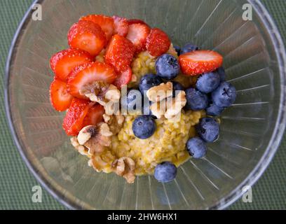 Bol d'épices de citrouille, flocons d'avoine coupés en acier avec fraises fraîches, myrtilles et noix. Petit déjeuner à base de plantes sain et copieux. Banque D'Images