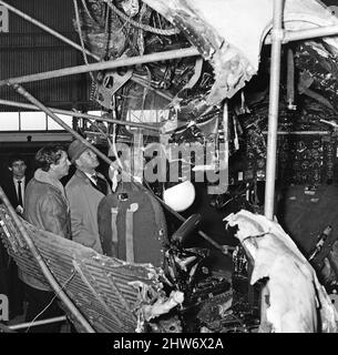 Le capitaine Harry Marlow, (laissé dans le col de laine) inspecte l'épave de son avion British Midland, maintenant à l'aérodrome de Farnborough.le capitaine Marlow a survécu à l'écrasement d'air de Stockport du 4th juin 1967 la catastrophe aérienne de Stockport a été l'écrasement d'un avion Canadair C-4 Argonaut appartenant à British Midland Airways, Inscription G-ALHG,[1] dans un petit espace ouvert à l'établissement espoirs Carr près du centre de Stockport, Cheshire, Angleterre, le dimanche 4 juin 1967. 72 des 84 à bord ont été tués dans l'accident. Sur les 12 survivants, tous ont été grièvement blessés. Elle est actuellement le quatrième désastre le plus grave de l’aviatio britannique Banque D'Images
