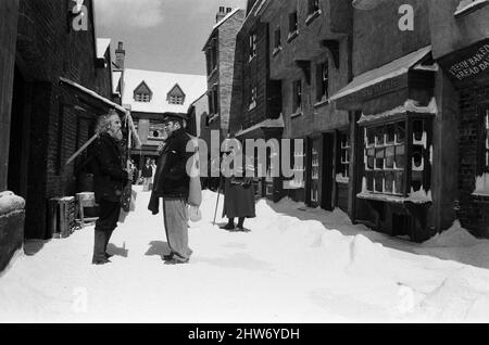 Tournage d'Oliver ! Aux studios Shepperton. La scène qui aurait dû être prise en milieu d'hiver était prise en août avec une tonne de polystyrène à plumes parsemée sur le point de représenter la chute de neige et les glaçons artificiels accrochés à des rebords et des tuyaux, etc. Photographiés à droite, Harry Secombe, qui joue M. Bumble, le gardien de l'atelier. 3rd août 1967. Banque D'Images