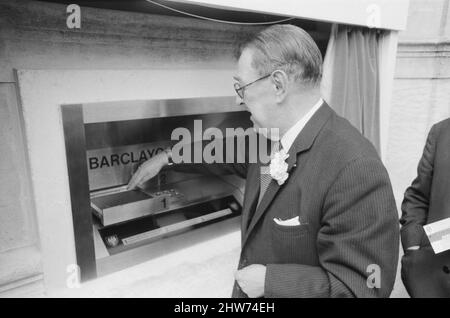 Le premier guichet automatique de Worlds, Cash machine, est dévoilé à la Barclays Bank, à Enfield, Middlesex, juste au nord de Londres. 27th juin 1967. L'image montre un client qui utilise la machine. Barclays ATM, 27th juin 1967. Sir Thomas Bland, vice-président de Barclays Bank, dévoile un robot de caisse qui distribue de l'argent à tout moment du jour ou de la nuit. Conçue et développée conjointement avec de la rue instruments et le service des services de gestion des banques, la machine BarclayCash est installée dans la succursale d'Enfield. L'acteur Reg Varney a pris le temps de filmer la série télévisée « Beggar Your Neighbor » à Northwood pour être TH Banque D'Images