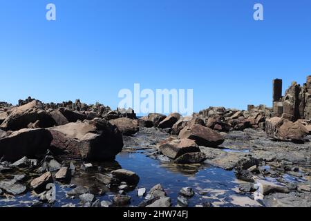 Vue panoramique sur la plage rocheuse de Bombo contre le paysage marin bleu lors d'une journée ensoleillée à Kiama, en Australie Banque D'Images