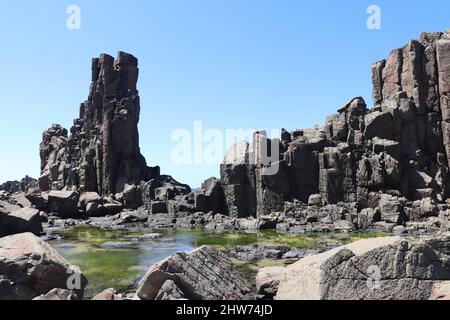 Vue panoramique sur la plage rocheuse de Bombo contre le paysage marin bleu lors d'une journée ensoleillée à Kiama, en Australie Banque D'Images