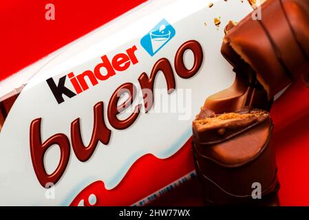 Gros plan du paquet de barres de chocolat au lait Kinder bueno et Kinder Bueno sur fond rouge Banque D'Images